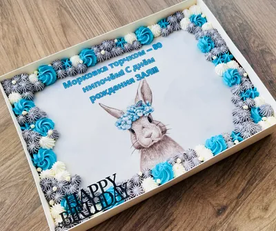 עוגת גן למבוגרים מלבנית עם ארנב במרכז ועיטורי קצפת כחולה, אפורה ולבנה מכל צדדיה