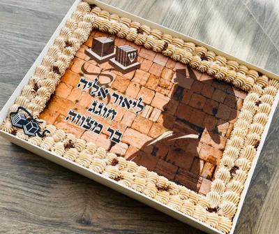 עוגת גן בר מצווה - עוגת שוקולד עסיסית ועשירה, עם גמאש שוקולד בלגי איכותי, מעוטרת בדף סוכר בעיצוב אישי וזילופי קרם צבעוניים שמוסיפים לחגיגה.